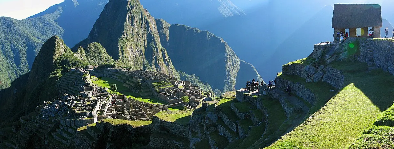 Machu Picchu at dawn, near-empty, with morning light raking across the citadel and Huayna Picchu