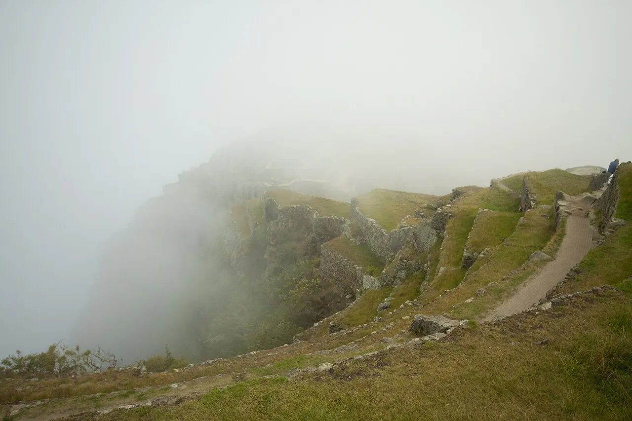 Cloud lifting off the terraced ridge of Machu Picchu on a wet, misty morning