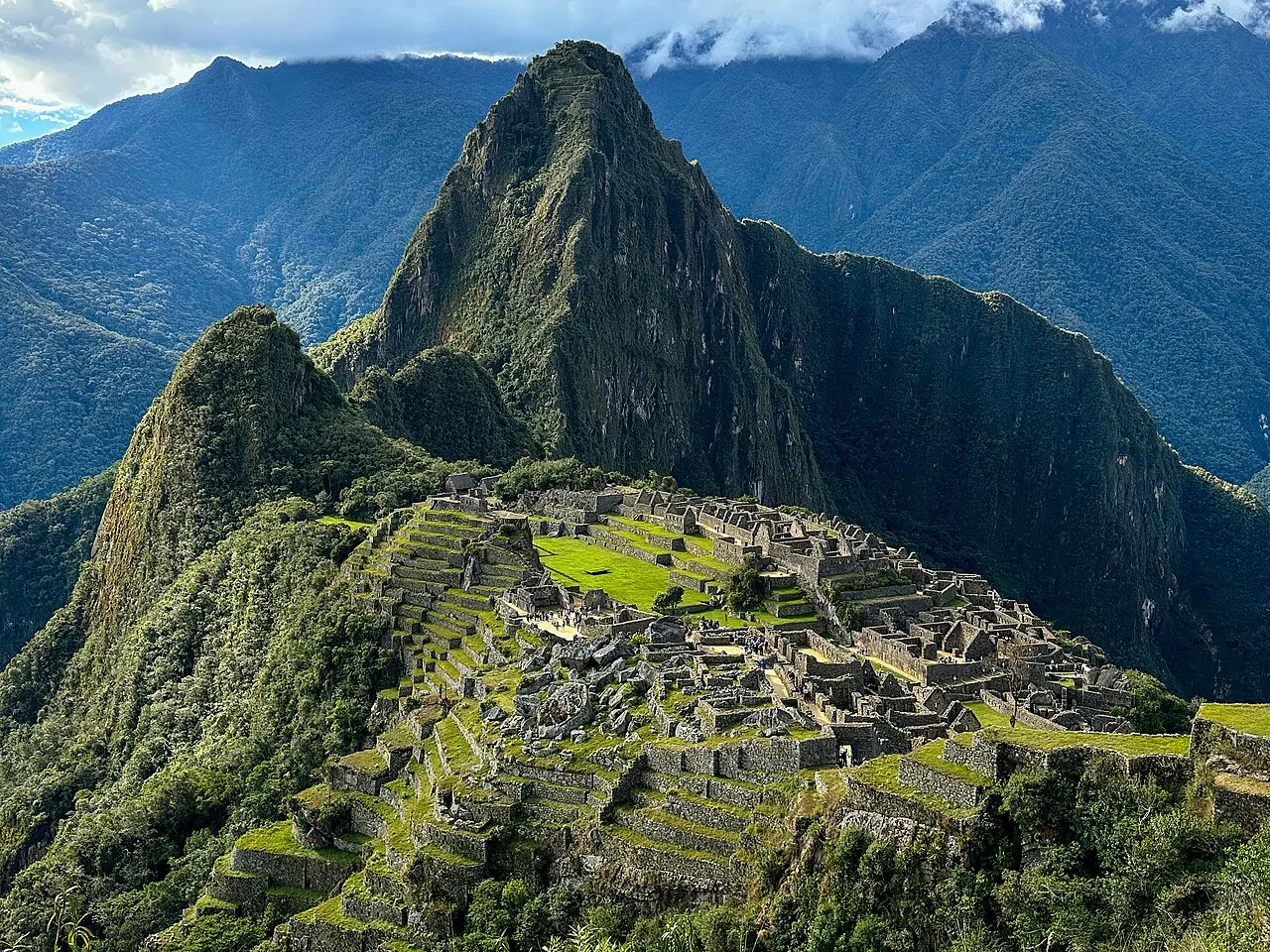 The classic Guardhouse overlook of the Machu Picchu citadel with Huayna Picchu and cloud behind