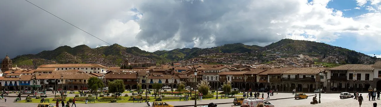 Cusco's Plaza de Armas with colonnaded buildings and red-roofed houses climbing the surrounding hills